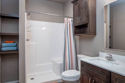 A bathroom with a toilet, sink, and shower.