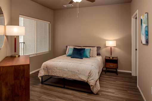 A bedroom with a bed, nightstands, and a ceiling fan.