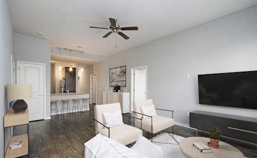 A living room with a white sofa, a black ceiling fan, and a black television.