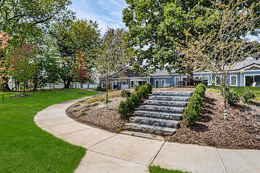 A residential area with a curved sidewalk and a row of houses.