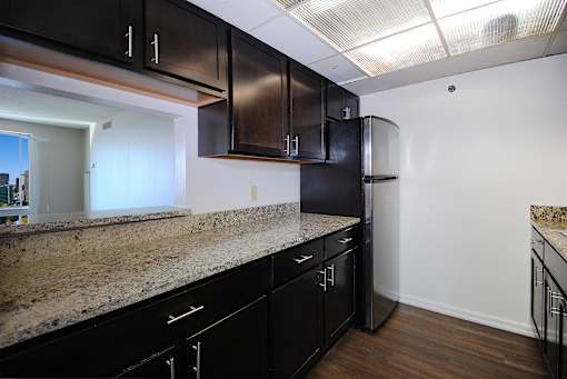 A kitchen with black cabinets and granite countertops.