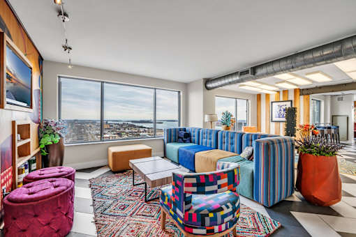 A living room with a large window and a view of the city.