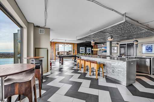 A modern kitchen with a bar area and a view of the city.