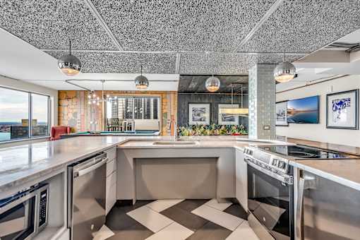 A modern kitchen with a checkered floor and stainless steel appliances.