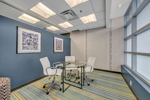 A conference room with a glass table and chairs.