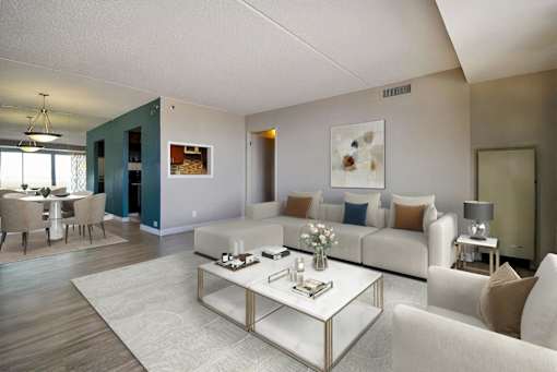 A modern living room with a glass coffee table and white couches.