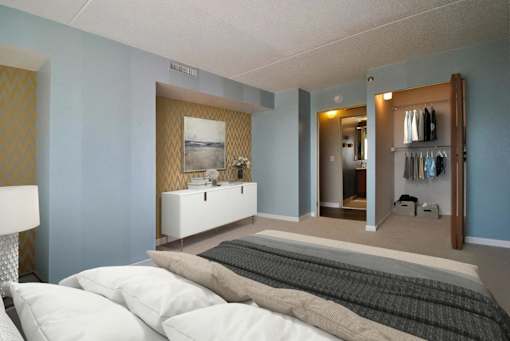 A bedroom with a bed, dresser, and mirror.