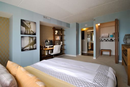 a bedroom with a bed and a desk in a hotel room
