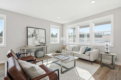 A living room with a brown leather chair and a glass coffee table.
