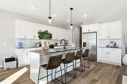 A modern kitchen with white cabinets and a central island.