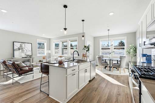 A modern kitchen with a large island and a dining area.