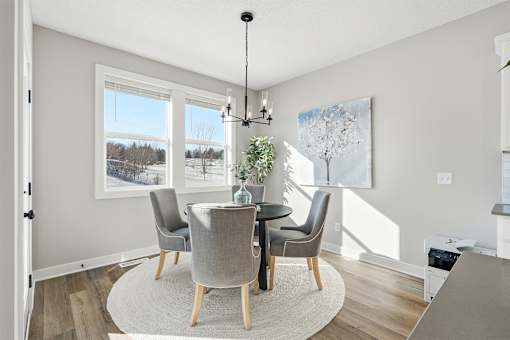 A dining room with a table and chairs.
