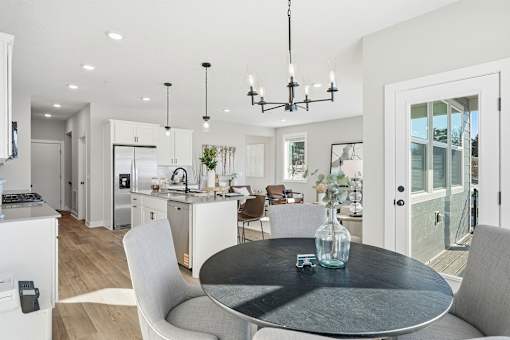 A modern kitchen with a dining table and chairs.