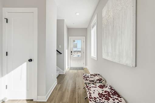 A hallway with a bench and a painting on the wall.
