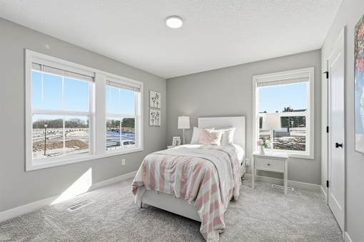 A bedroom with a large bed and a view of a snowy landscape outside the window.