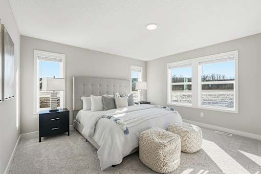 A bedroom with a large bed and a window overlooking a snowy landscape.