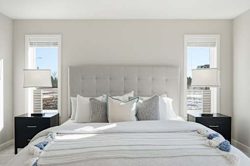 A bedroom with a large bed and two lamps.