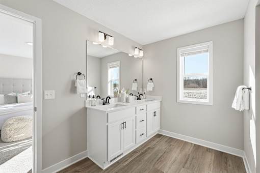 A bathroom with a vanity, mirror, and lighting fixtures.