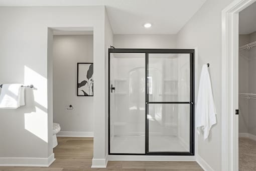 A white bathroom with a glass door.