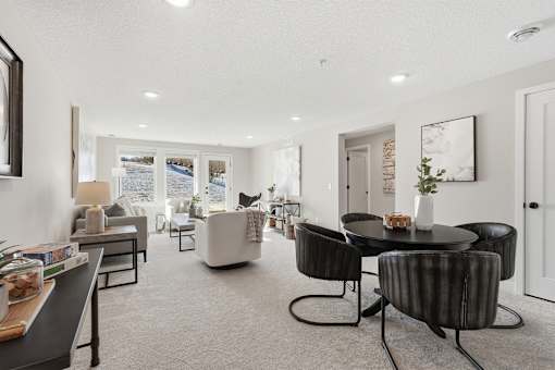 A modern living room with a black table and chairs.