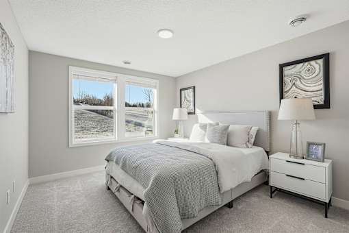 A bedroom with a large bed and a window showing a snowy landscape outside.