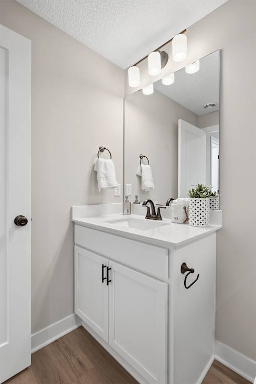 A white bathroom with a sink and mirror.