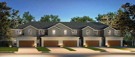 A large, two-story house with a dark grey exterior and a black roof.