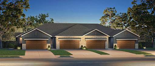 A large house with a grey roof and four garages.
