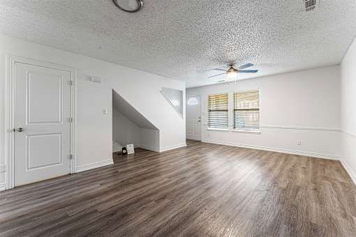 A room with a wooden floor and a ceiling fan.