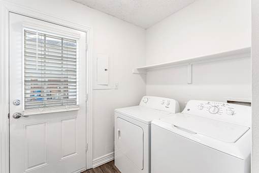 A white laundry room with a washer and dryer.