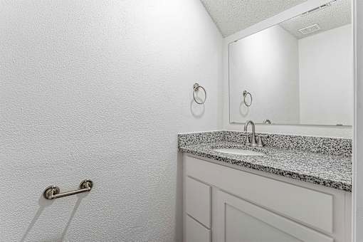 A bathroom with a sink and a mirror.