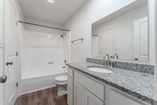 A bathroom with a toilet, sink, and bathtub.