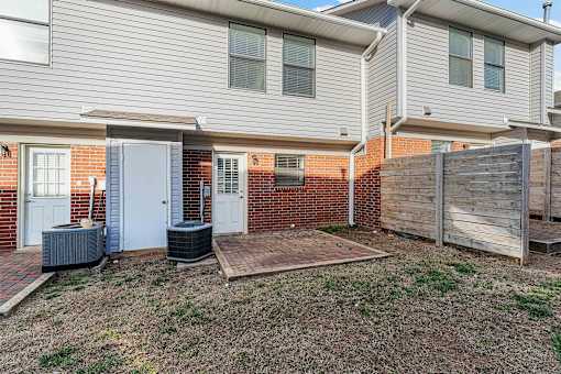 A house with a grey siding and a brick wall.