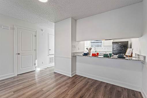 A kitchen with white cabinets and a wooden floor.
