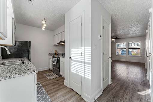 A kitchen with a black fridge and a white counter top.