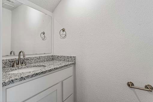 A bathroom with a sink and a mirror.