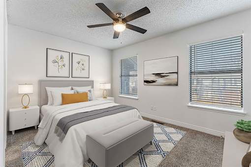 A bedroom with a bed, nightstands, and a ceiling fan.