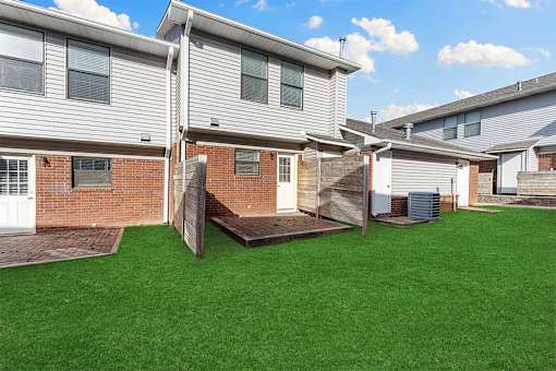 A row of houses with a green lawn in front.