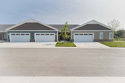 A large, two-story building with a garage door on each side.