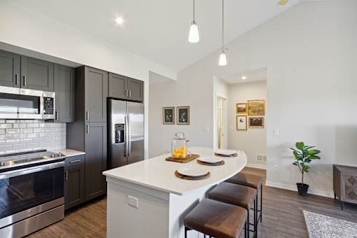 A modern kitchen with a white island and stainless steel appliances.