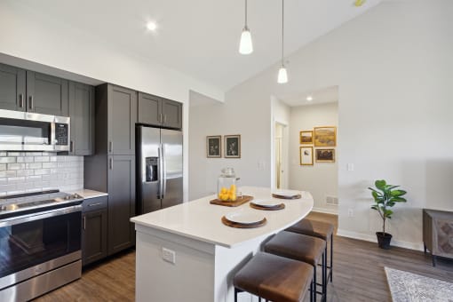 a kitchen with a large island and stainless steel appliances
