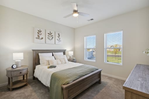 a bedroom with a bed and two windows
