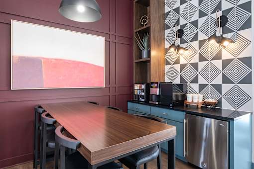 A modern kitchen with a wooden table and stainless steel appliances.
