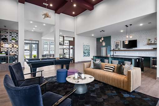 A modern living room with a pool table and a couch.