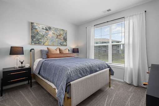 A bedroom with a large bed and a painting on the wall.