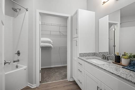 A white bathroom with a walk-in shower and a sink.