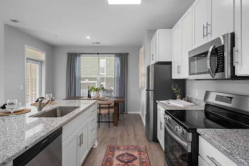A kitchen with black appliances and white cabinets.