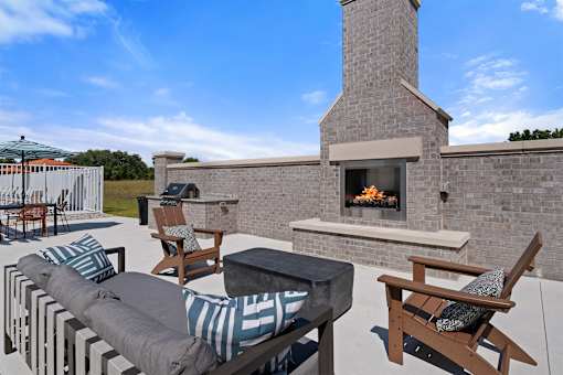 A patio with a fireplace and seating area.