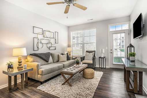 A living room with a couch, a coffee table, and a television.