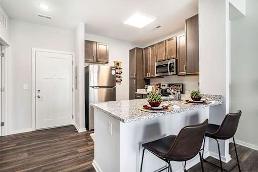 A kitchen with brown chairs and a white counter.